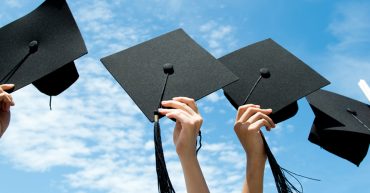 People holding their graduation hats